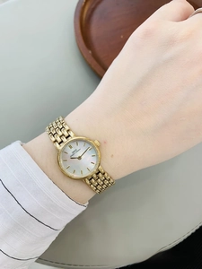 Detail of IBSO women's gold watch with mother-of-pearl dial and woven metal strap