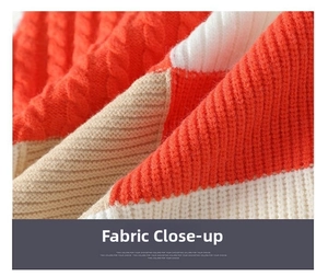 Close-up of thick cable-knit texture with orange, beige and brown color-blocking