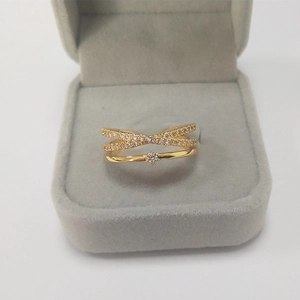 Macro detail of gold layered crossover ring with micro-pave cubic zirconia accents