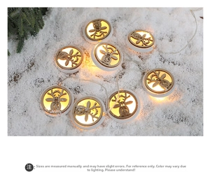 Detail of wooden reindeer LED string lights with warm glow on a snowy holiday background