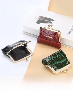 Detailed view of crocodile texture coin purses in wine red, dark green, and black with kiss-lock