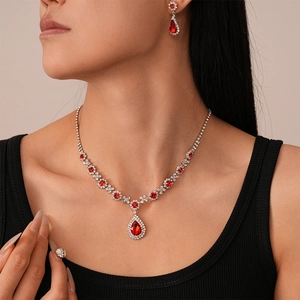 Detailed view of luxury necklace and earrings set with red water drop gemstones