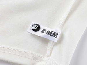 Detail view of white modal fabric with washing label, brand logo, and size S button