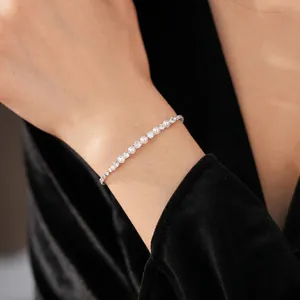 Elegant zircon pearl chain bracelet on wrist with high contrast black velvet background