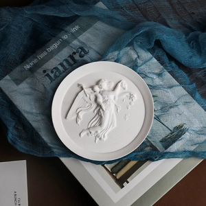 Detailed relief of angel scene on a round plaster tray for elegant home decor