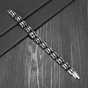 Retro multi-layer stainless steel and black silicone men's bracelet on a wooden desk