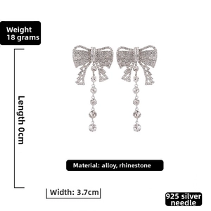 Detail view of rhinestone bow earrings showing 8cm length and 3.7cm width dimensions