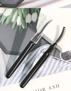 Macro detail of portable silicone eyelash brushes with protective cap on marble surface
