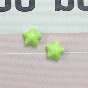 Macro detail of two lime green macaron resin star charms for DIY jewelry and hair accessories