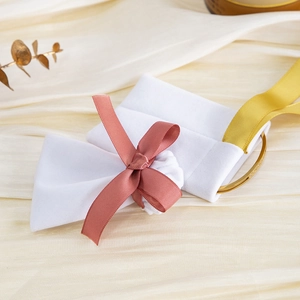 Detailed view of a white velvet jewelry bag with pink and yellow silk ribbons