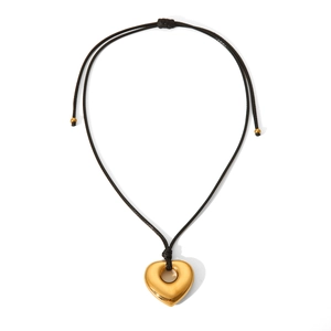 Golden heart pendant necklace with black wax cord on a clean white background