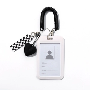Detail of checkered card holder with retractable heart keychain on white background