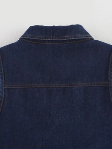 Détail du dos d'une veste en jean bleu foncé avec coutures marron et texture sergé