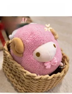 Pink plush sheep toy with brown horns and bow in a woven basket display for kids