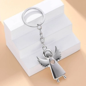 Polished silver alloy angel keychain with heart cutout on creative geometric background