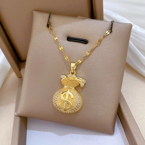 Macro detail of gold money bag pendant with sparkling crystals and dollar sign symbol
