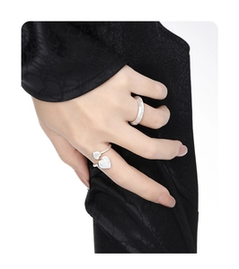 Detail of silver S925 heart ring and brushed textured band on model fingers