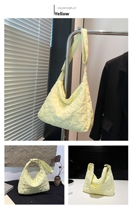 Close-up of star-quilted stitching on light yellow nylon tote bag with zipper detail