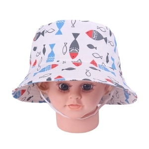 Detail of white cotton baby sun hat with colorful fish pattern and elastic chin strap