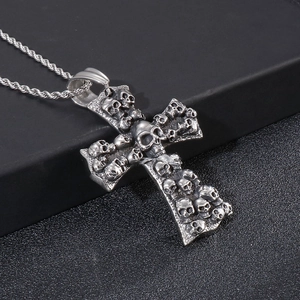 Detailed close-up of a punk cross pendant with skull relief on a twisted rope chain