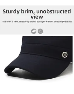 Detail of a navy flat top cap brim with a metallic nautical badge and premium stitching