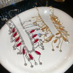 Detailed macro view of crystal tassel necklaces in gold and silver plating with water-drop pendants