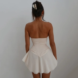 Detail of backless strapless beige dress with ruffled hemline and lace-up back design