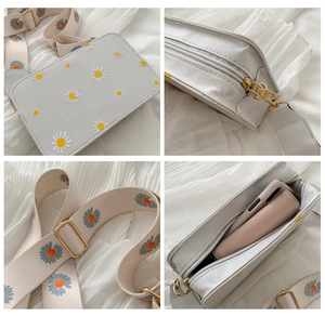 Detail views of daisy printed square bag with embroidered wide strap and zip closure