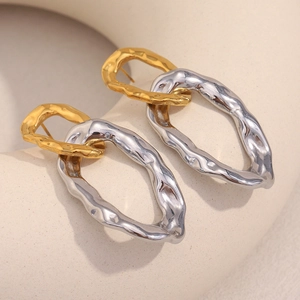Close-up of interlocking metal link earrings featuring a hammered texture in gold and silver