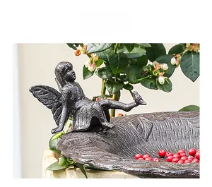 Detalle del comedero para pájaros en hierro fundido envejecido con figura de hada
