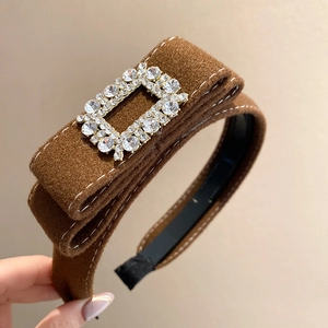 Detail of brown velvet headband featuring a square rhinestone buckle for a luxury look
