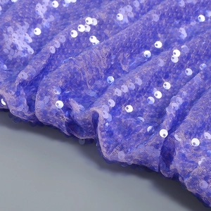 Dettaglio ravvicinato di paillettes viola scintillanti su tessuto mesh per abiti da festa