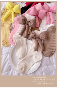 Close-up of baby ribbed knit long socks with large 3D cotton-filled bow decorations