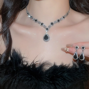 Detail of luxury teardrop jewelry set with black gemstones and crystals on model