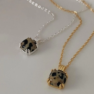 Detail view of square Dalmatian jasper pendants in gold and silver plating