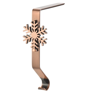 Close-up of copper metal Christmas stocking hook featuring a detailed snowflake design