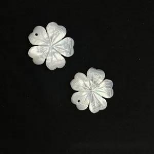 Macro detail of two hand-carved white shell flower petals with iridescent pearl luster
