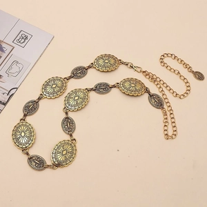 Detailed macro view of vintage gold chain belt with sun-pattern oval medallions