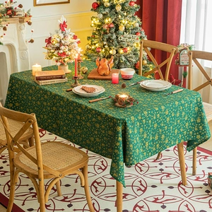Green Christmas tablecloth with golden reindeer and snowflake prints on festive table