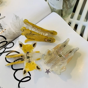 Detail of cute golden retriever and cat shaped acetate hair clips for daily styling