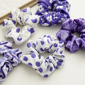 Set of five purple and white floral fabric scrunchies in various patterns and textures
