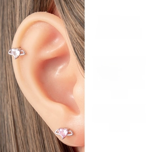 Close-up of titanium steel angel wing ear studs with pink and white heart cubic zirconia