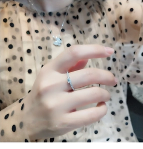Macro shot of silver plated ring with light blue rectangular crystal and small diamonds
