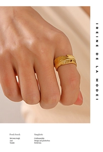 Detailed close-up of a golden feather wrap ring showing intricate vein textures on a hand