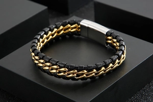 Close-up of woven black leather bracelet with gold metal chain inlay and silver magnetic clasp