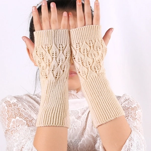 Detail of beige knit arm warmers featuring a leaf pattern cutout and fingerless design