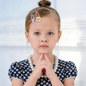 Detailed view of child hair clips featuring colorful sequins and a rhinestone sunflower design