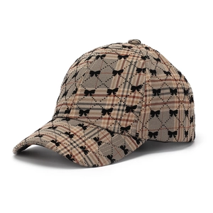 Detailed view of khaki plaid baseball cap with black mini bows and rigid curved brim