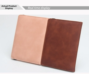 Detail view of pink and brown leather passport covers with fine stitching and matte texture