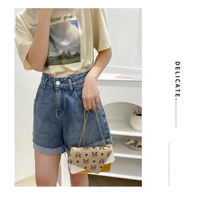 Close-up of stylish chain shoulder bag with colorful panels and delicate metallic chain